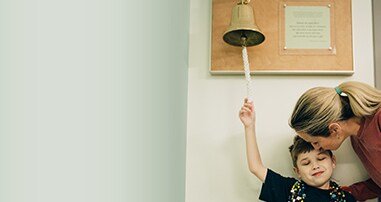 little boy cancer patient ringing end of treatment bell