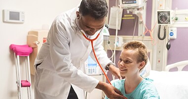 Dr. Chandrakasan checking on female cancer patient