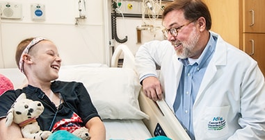 pediatric cancer patient laughing with psychologist