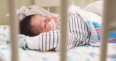 young pediatric patient in hospital crib