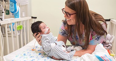 Neonatal intensive care nurse with baby patient in the hospital.