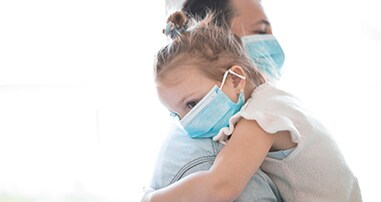 Dad and daughter wearing masks for pediatric care