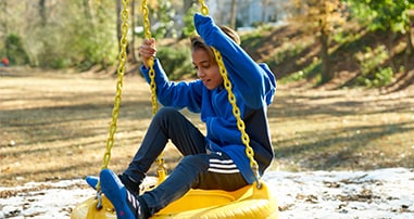 boy playing on a tire swing