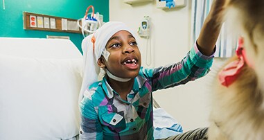 epilepsy patient petting therapy dog in hospital bed