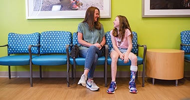 Parent and patient in waiting room before limb difference clinic visit.