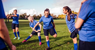 Teen athletes stretching before a game