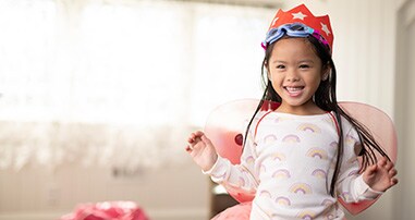 Happy young girl plays dress up.