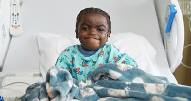 A transplant patient sits in a hospital bed