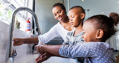 kids washing hands with mom