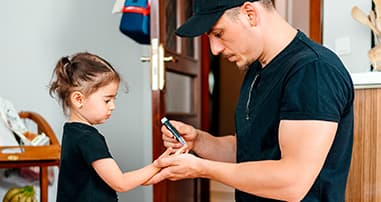 Dad checking child's blood sugar levels