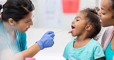 Pediatric ENT examining patient for strep throat. 