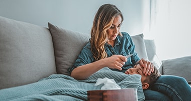 Mom reading thermometer to check son's fever