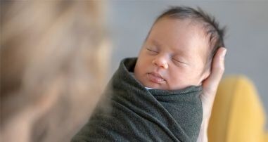 a baby safely swaddled in mother's arms