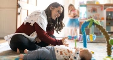 mother playing with a baby on his back