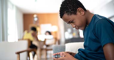 Teen boy playing game on phone