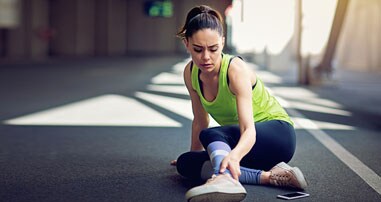 Teen girl runner grabbing leg because of muscle cramp