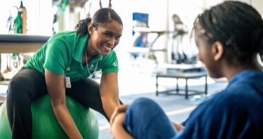 physical therapist looking at young athlete's leg