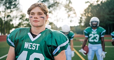 Teen football players on the field before a game.