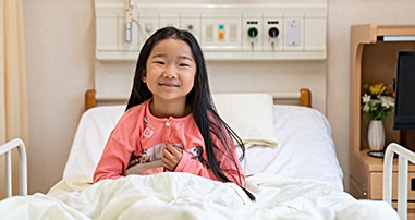 child smiling in hospital bed