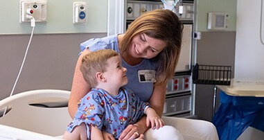 patient boy smiling next to mom before surgery in pediatric hospital