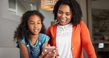 Teen girl showing mom her mobile phone