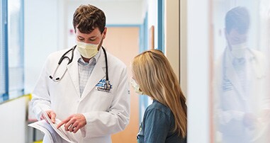 pediatric-cancer-doctor-reviewing-handout-with-nurse-in-hallway