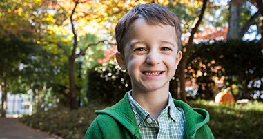 Pediatric heart surgery patient smiling outside hospital