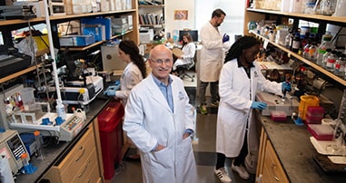 Pediatric cancer doctor smiles in research laboratory