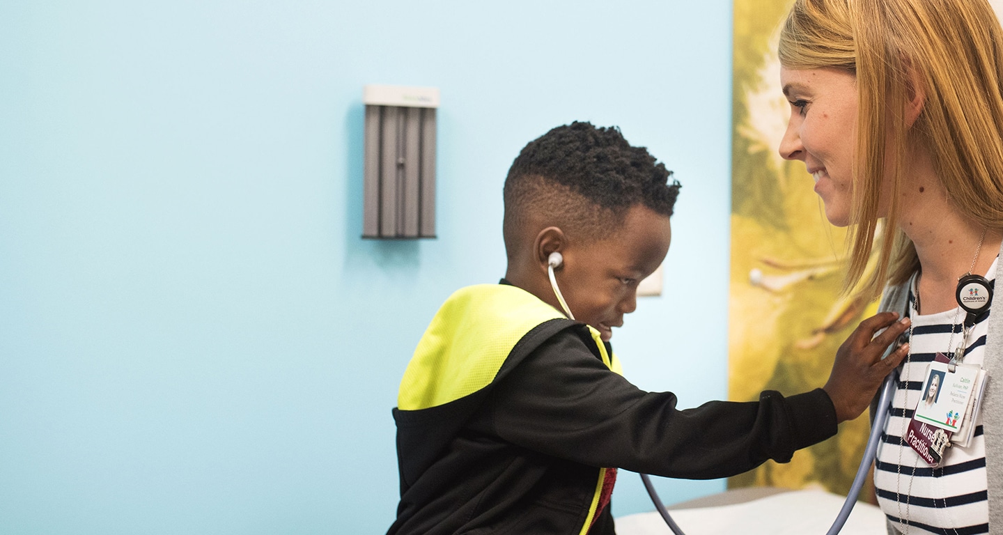 Boy patient checking doctor with stethoscope