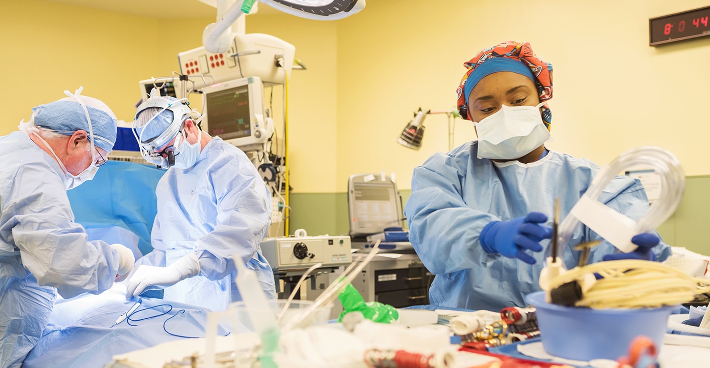 3 doctors performing procedure in pediatric operating room