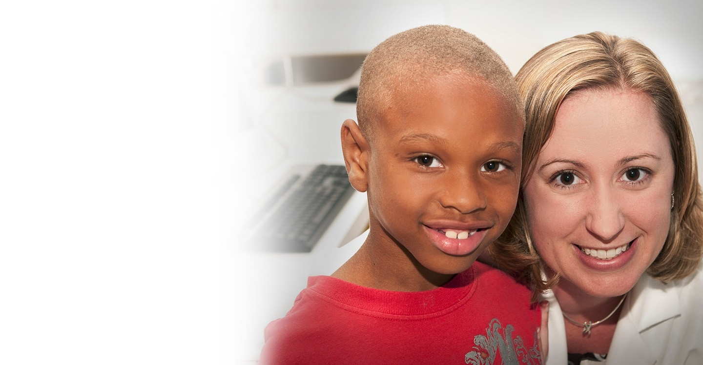 Liver transplant pharmacist with boy patient in clinic