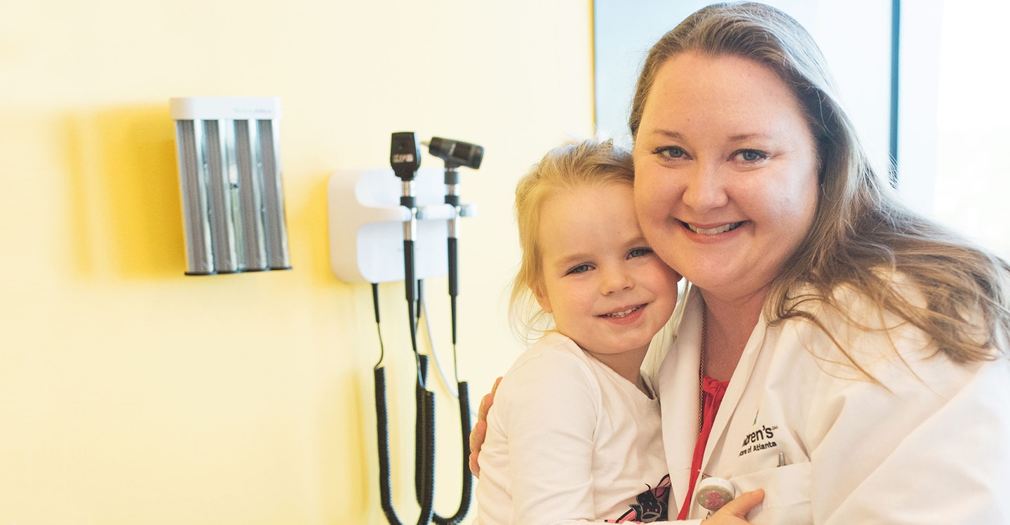 Advanced practice practitioner with young girl in clinic