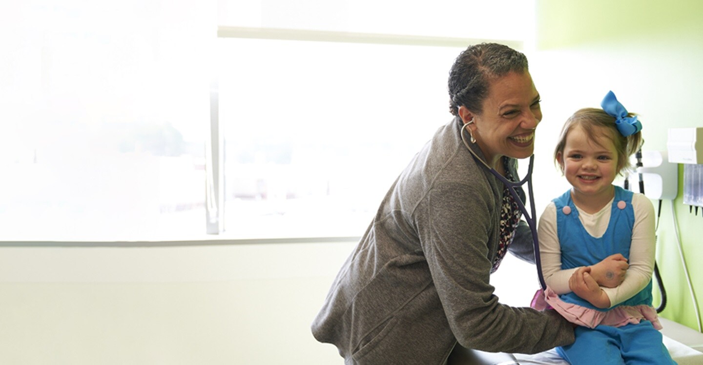 Dr. Ann-Marie Brooks with young girl patient in clinic