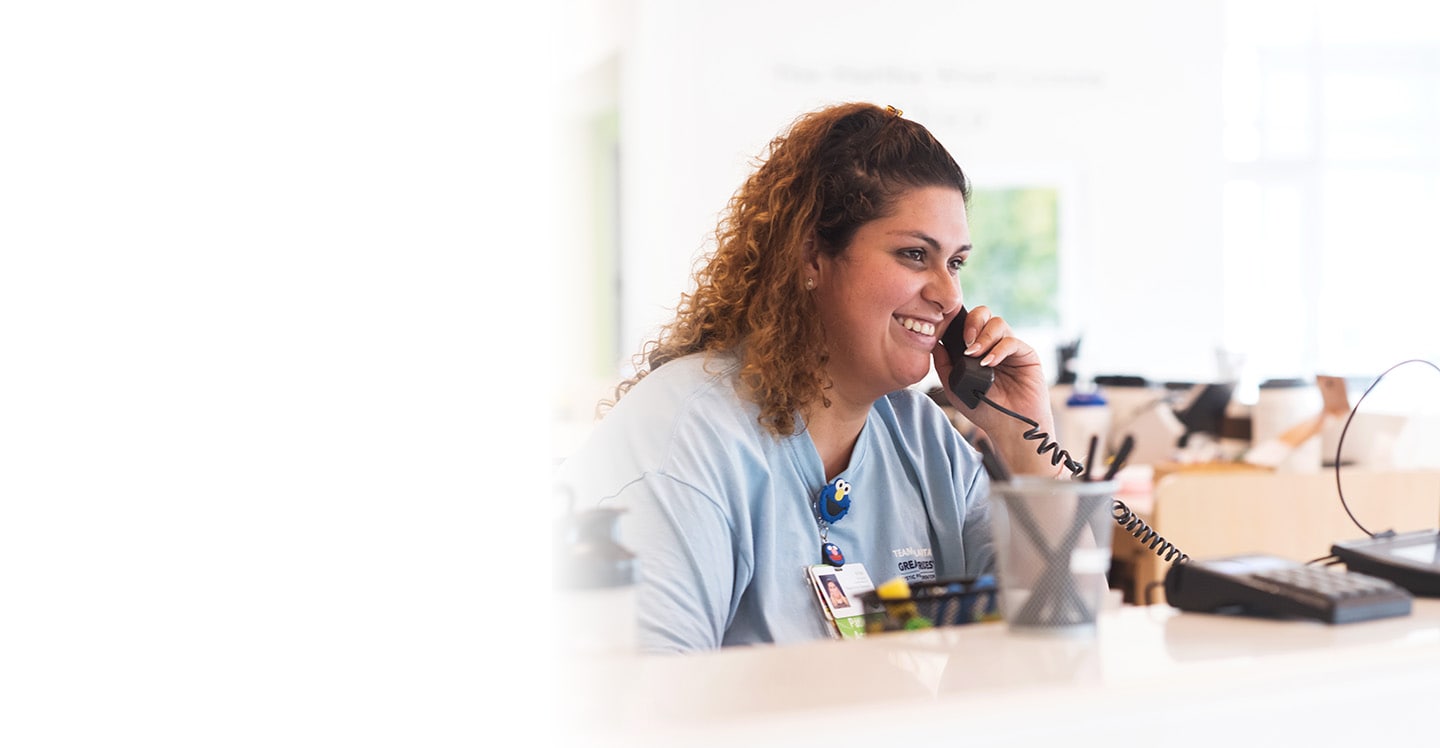 Children's staff member on phone at desk in the Center for Advanced Pediatrics