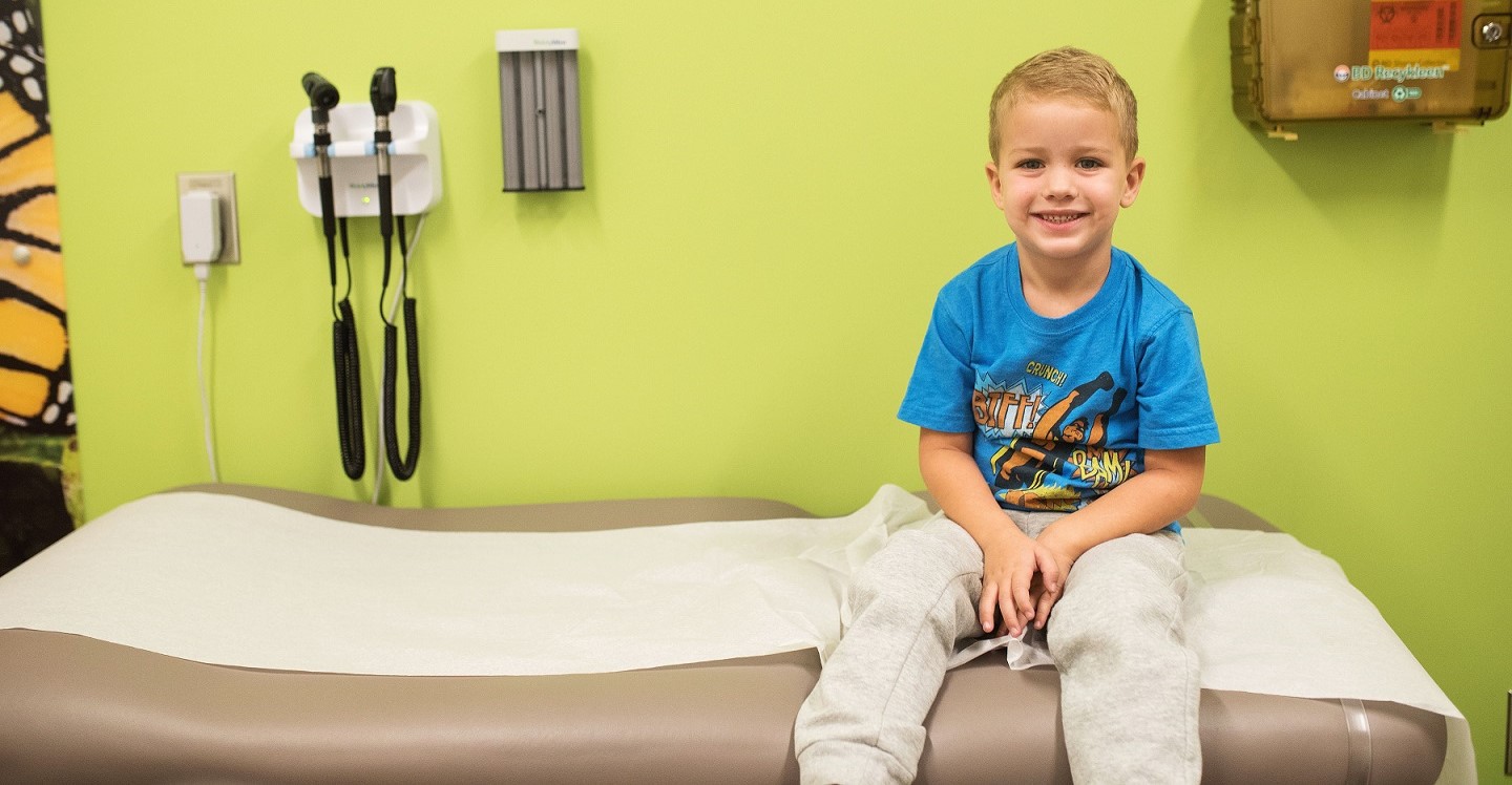 little boy sitting on exam table