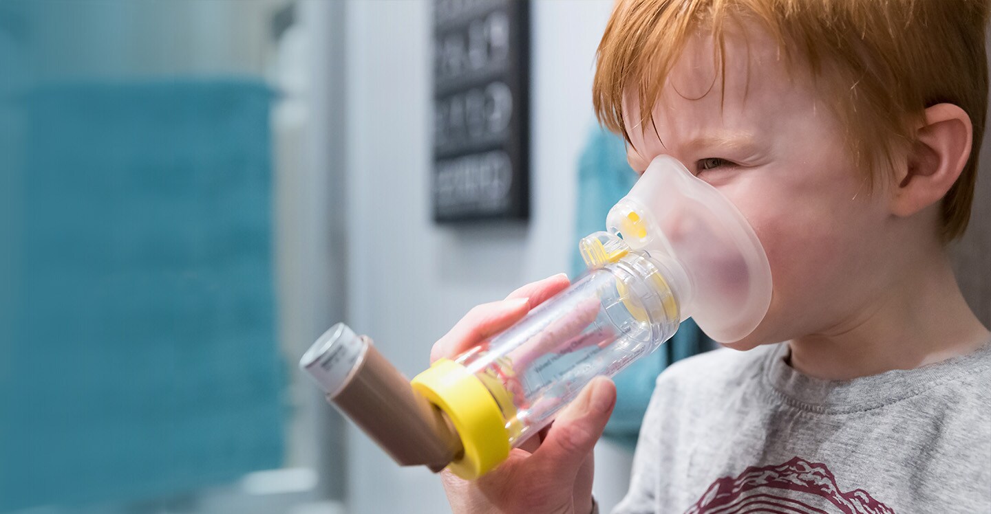 boy smiling with inhaler spacer