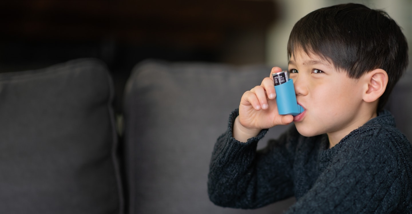 Child with asthma using inhaler