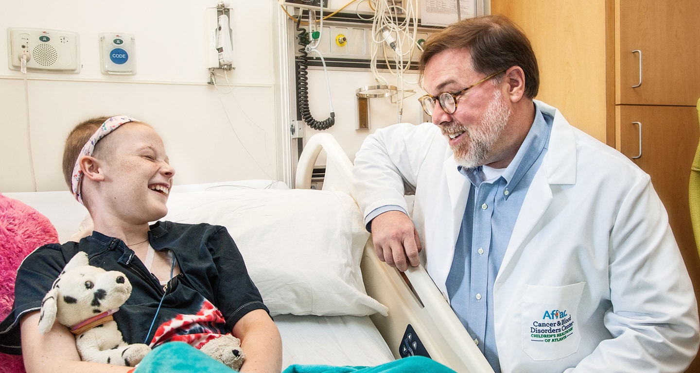 girl cancer patient laughing with doctor