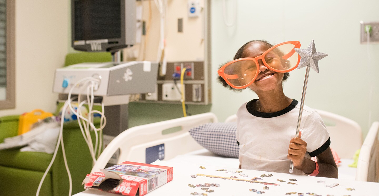 Intestinal rehab patient smiles in hospital bed.