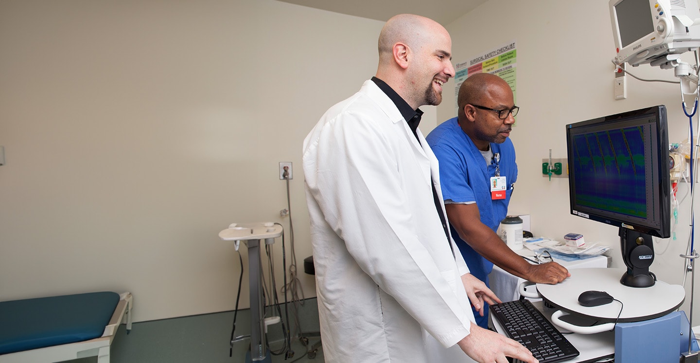 Motility Program physician Dr. Garza examines computer image.