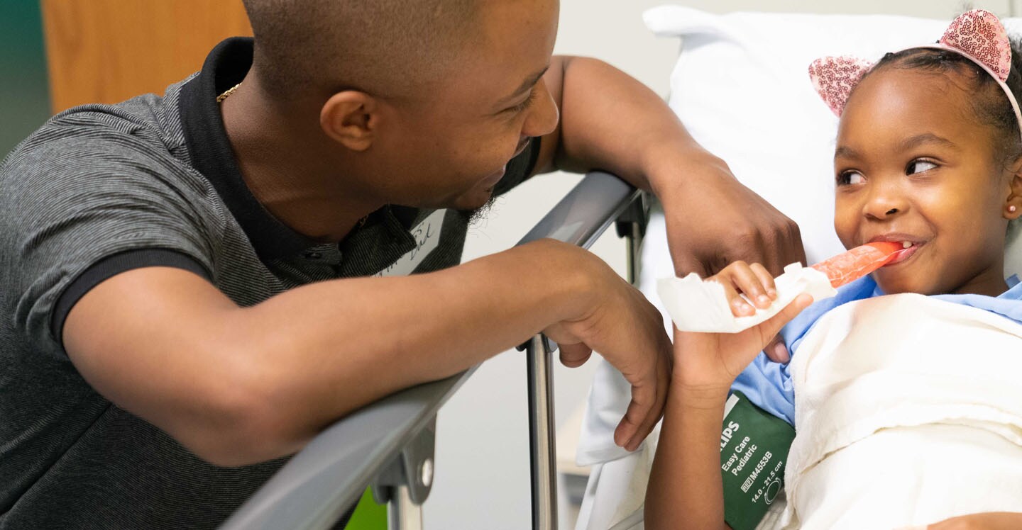 Pediatric girl patient with dad eating popsicle