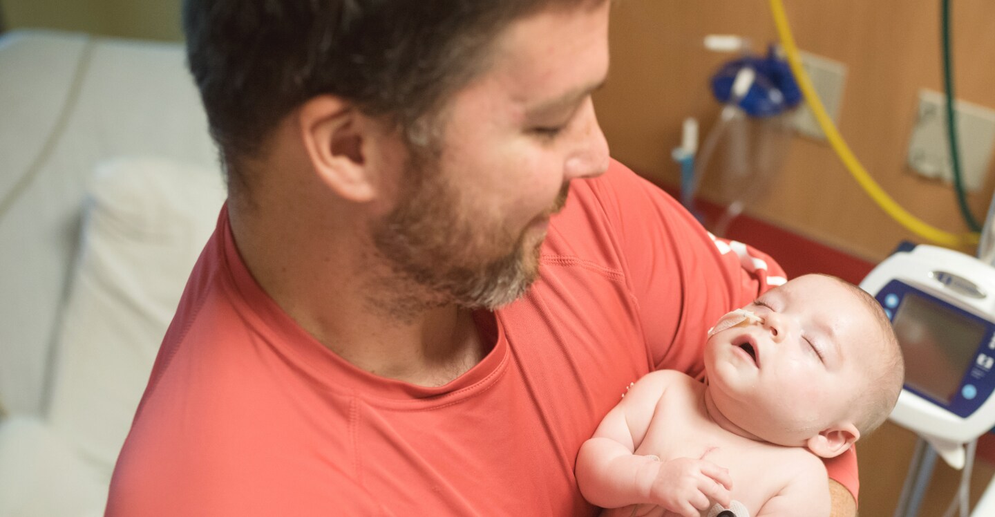 Father holding child in hospital