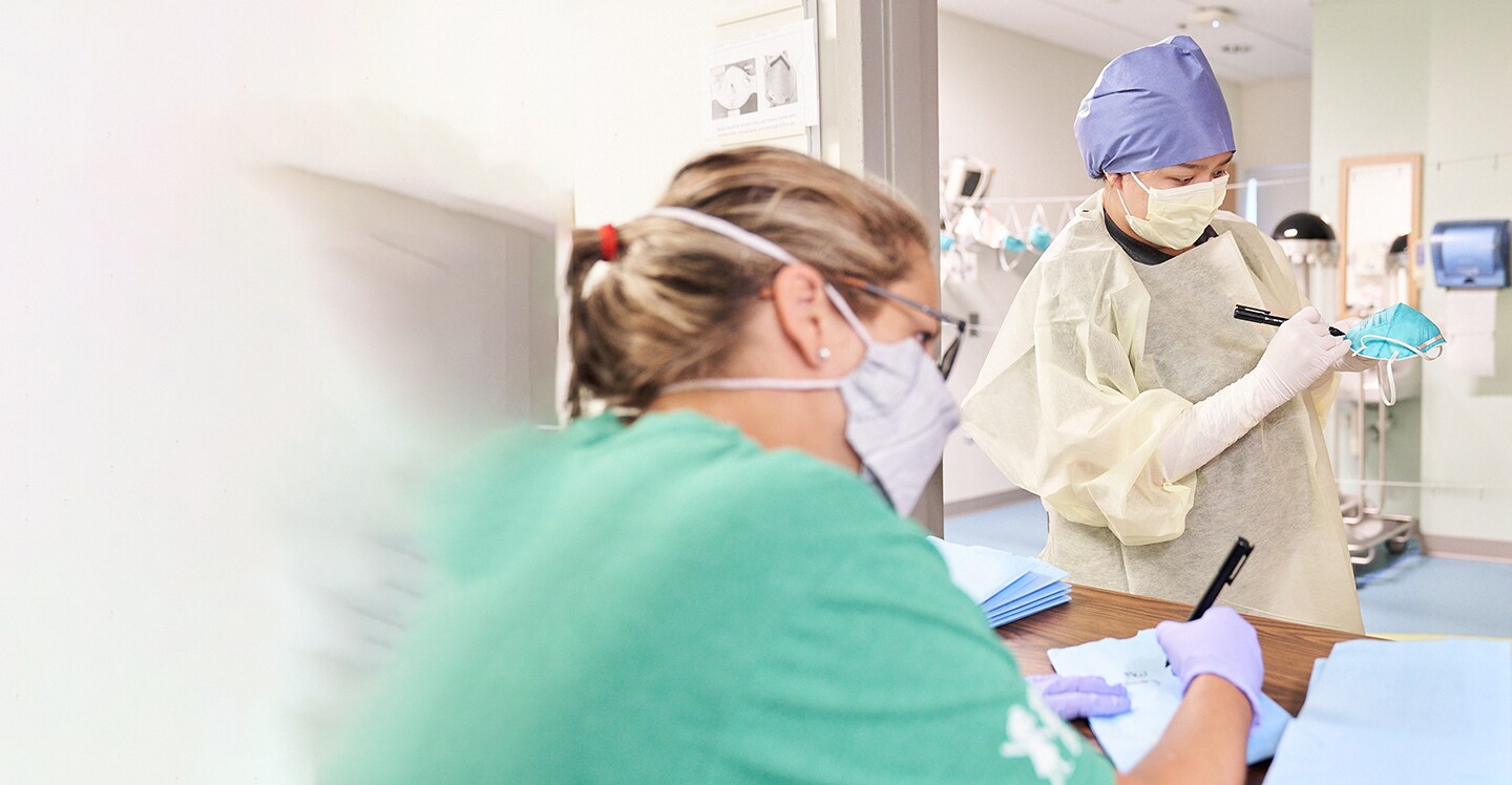 Employees wearing masks and cleaning PPE