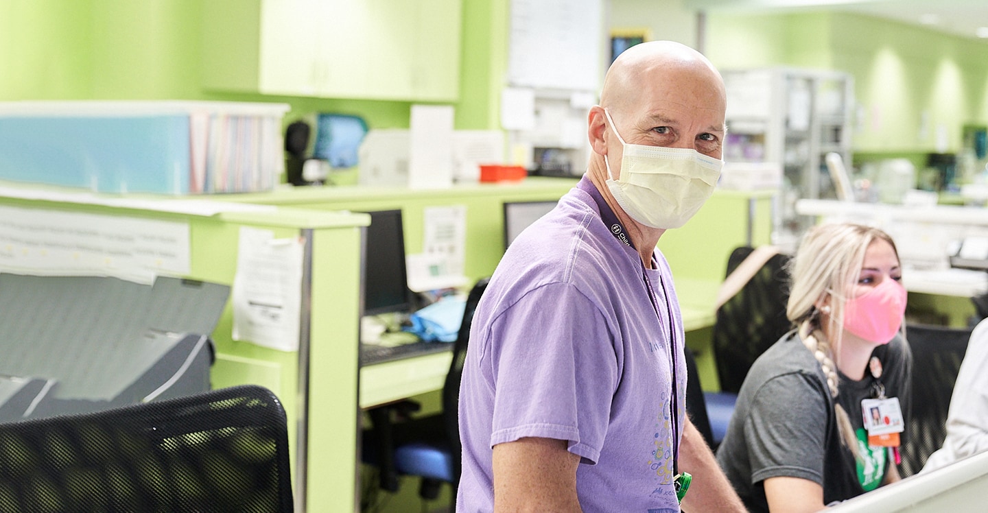 Staff wearing masks at check-in desk and smiling