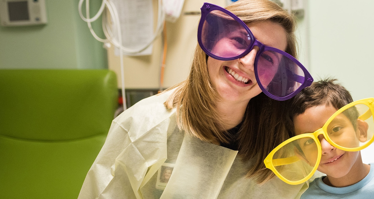 Nurse and a pediatric patient smiling with sunglasses