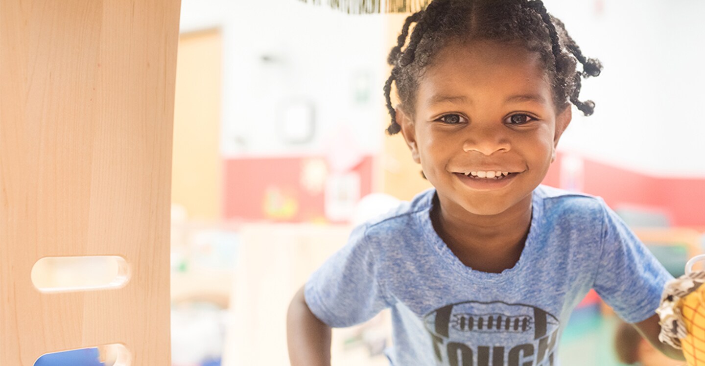 young boy smiling with football on shirt