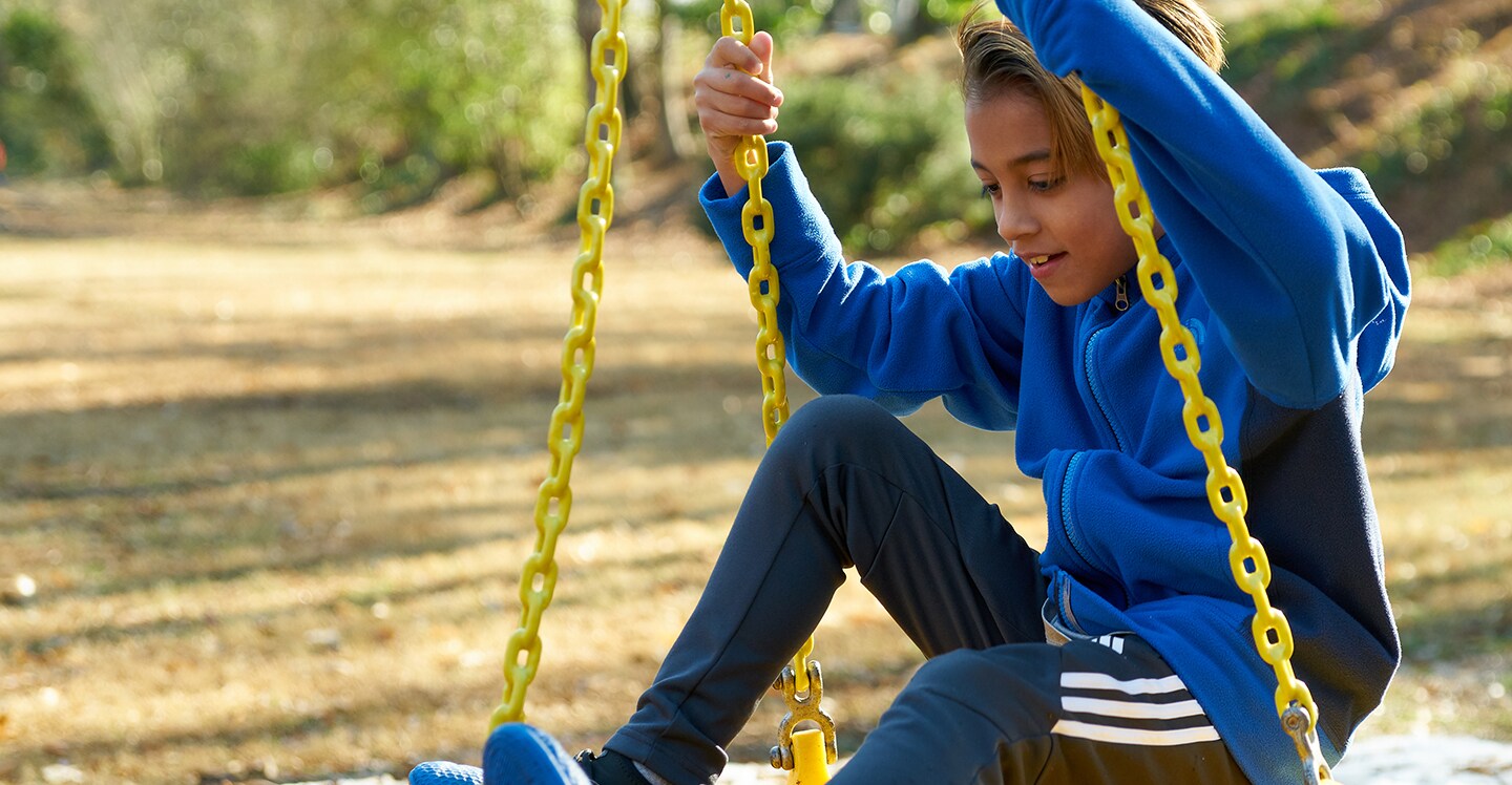 boy playing on tire swing