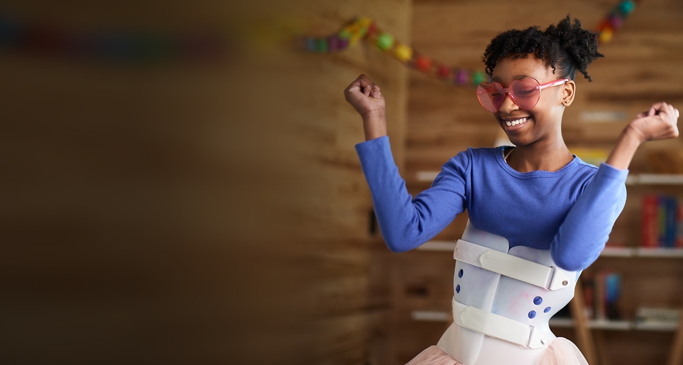 Teen girl with a scoliosis brace dancing 