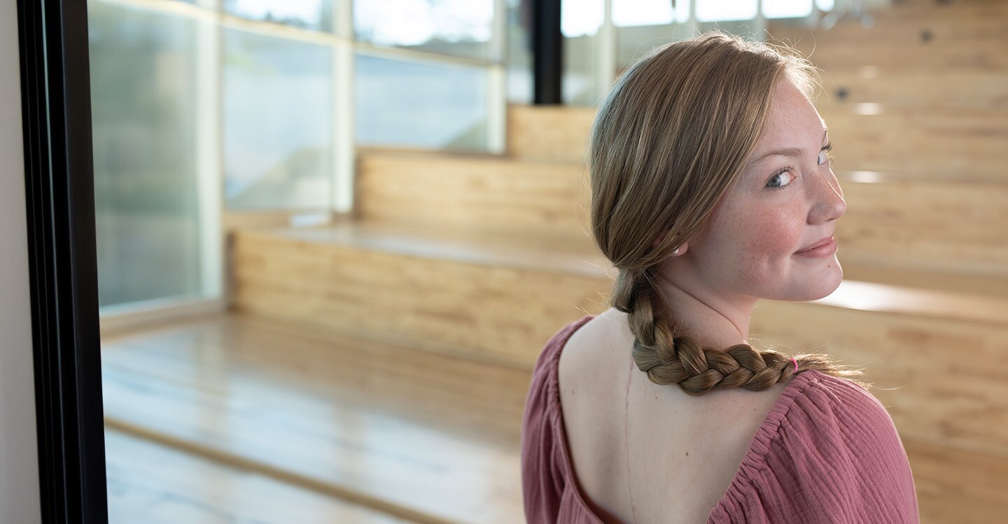 Scoliosis surgery patient smiling and showing back scar.