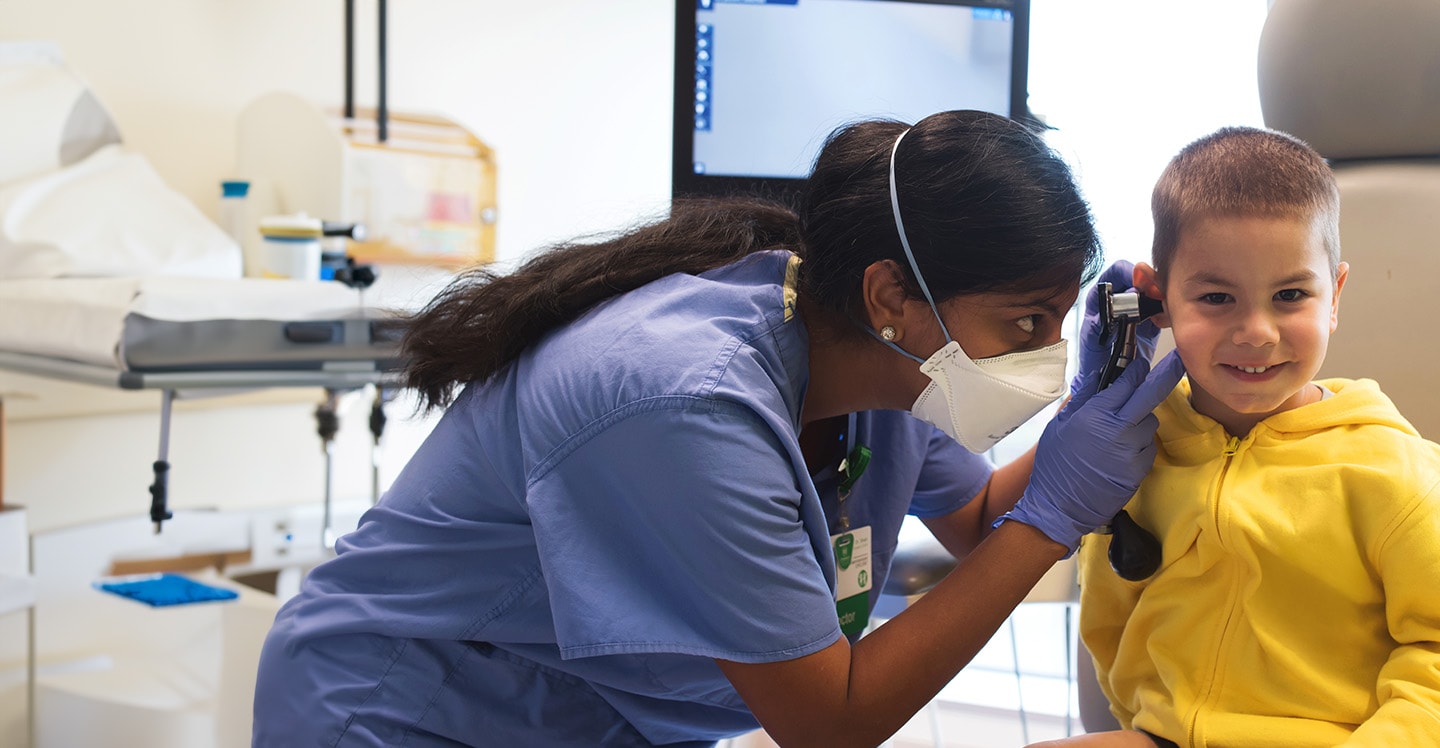 Dr. Shah examines a young boy's ear during a clinic visit.